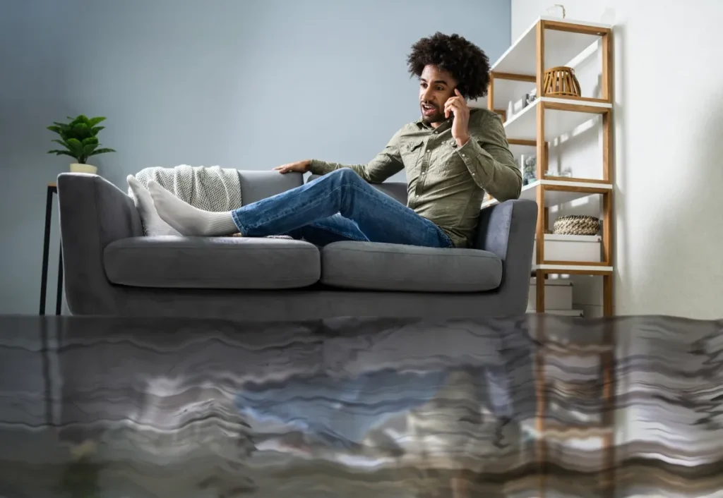 homem sentado no sofá enquanto conversa pelo telefone