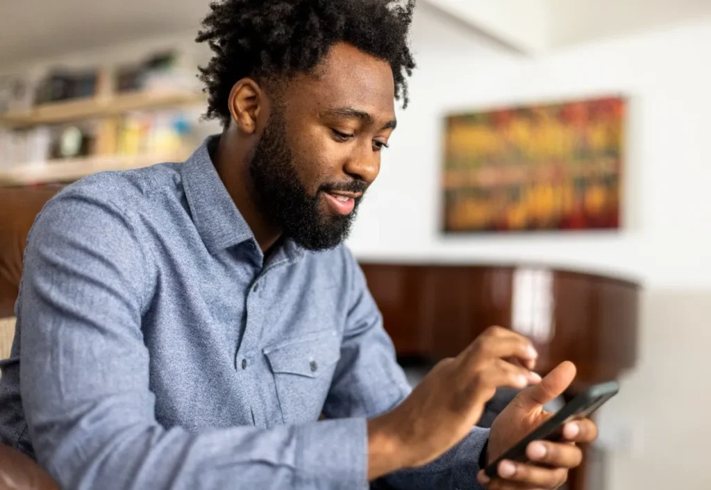 homem sentado mexendo no celular