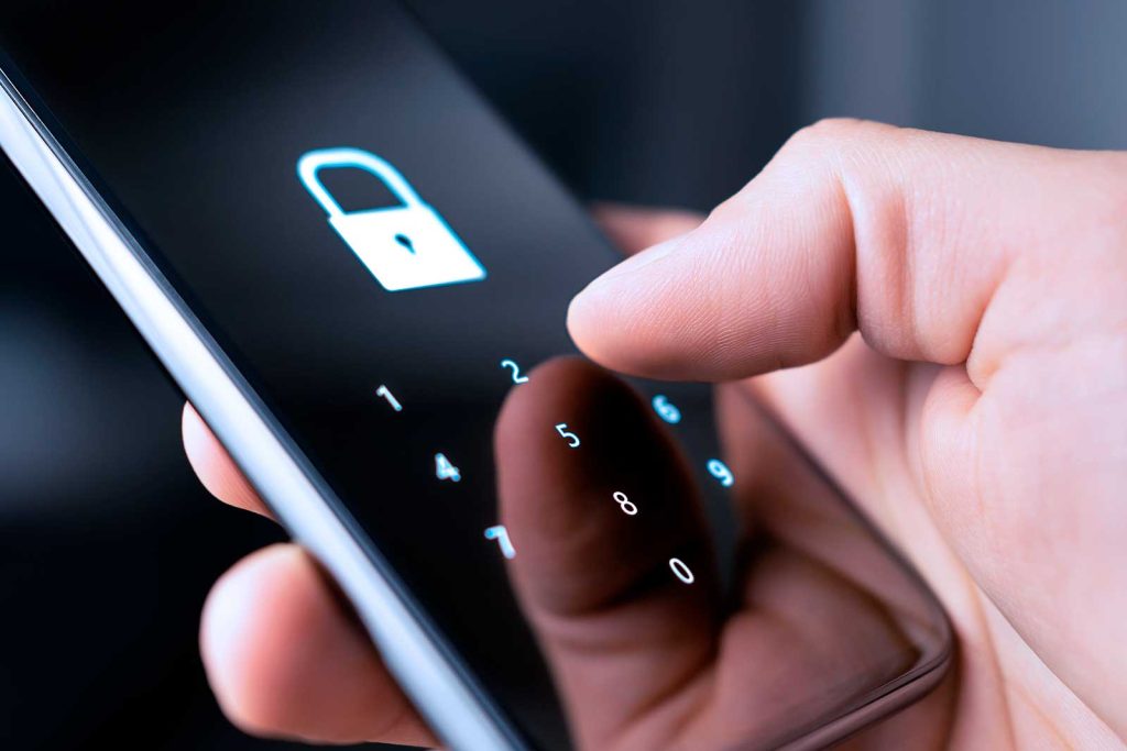 Pessoa digitando senha em smartphone com ícone de bloqueio