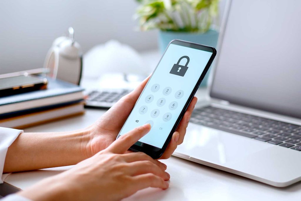 Pessoa digitando senha em smartphone com cadeado na tela