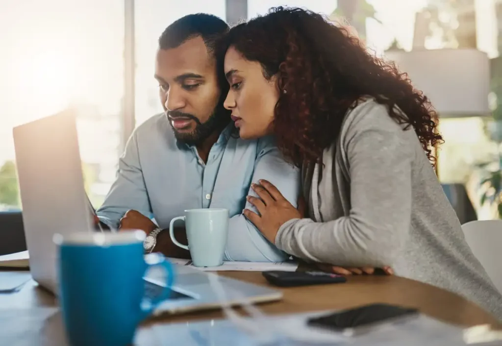 casal abraçado conferindo algo no notebook