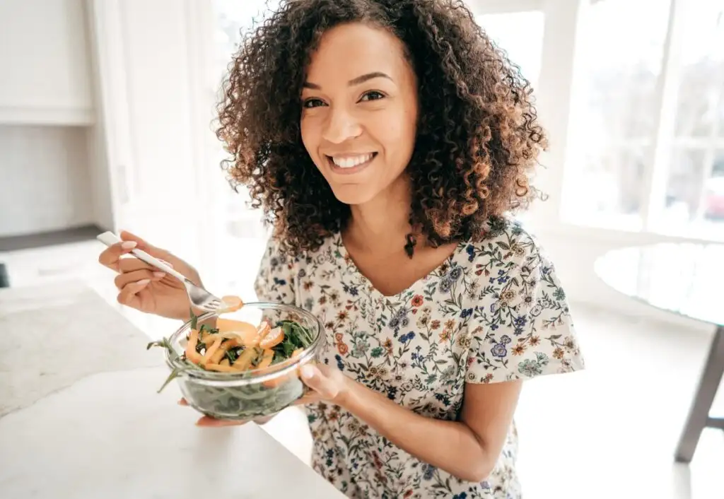 mulher comendo um prato de salada
