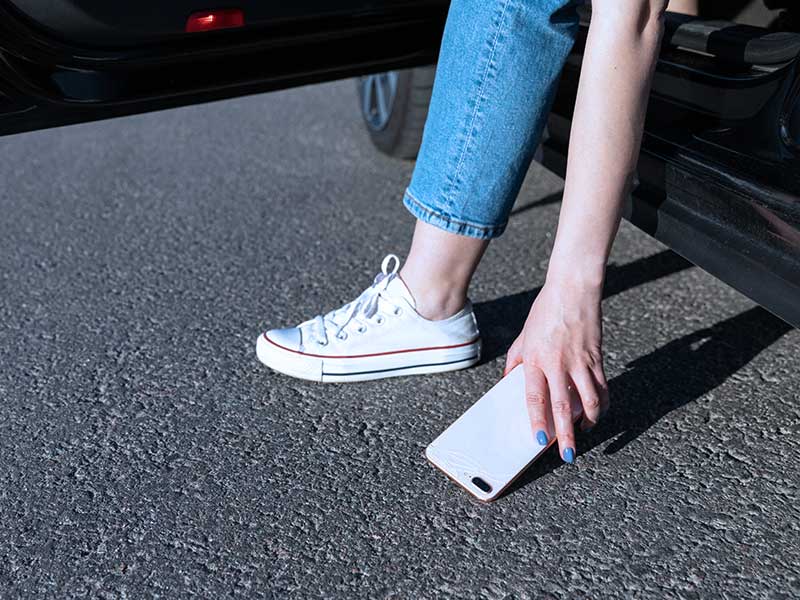 Mulher pegando celular do chão