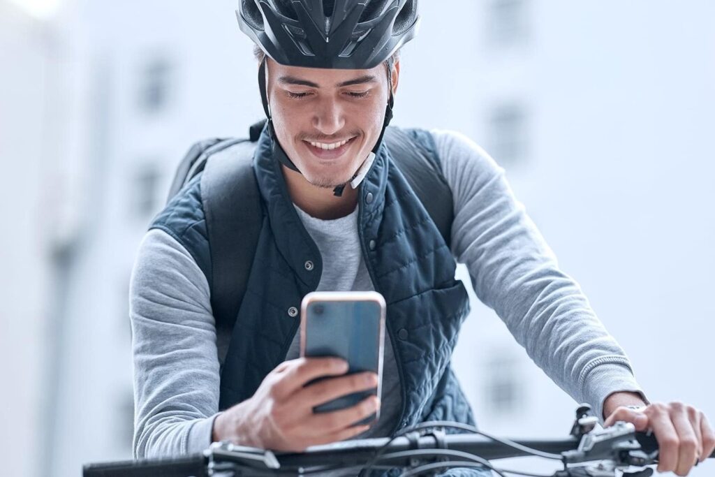 ciclista segurando celular parado