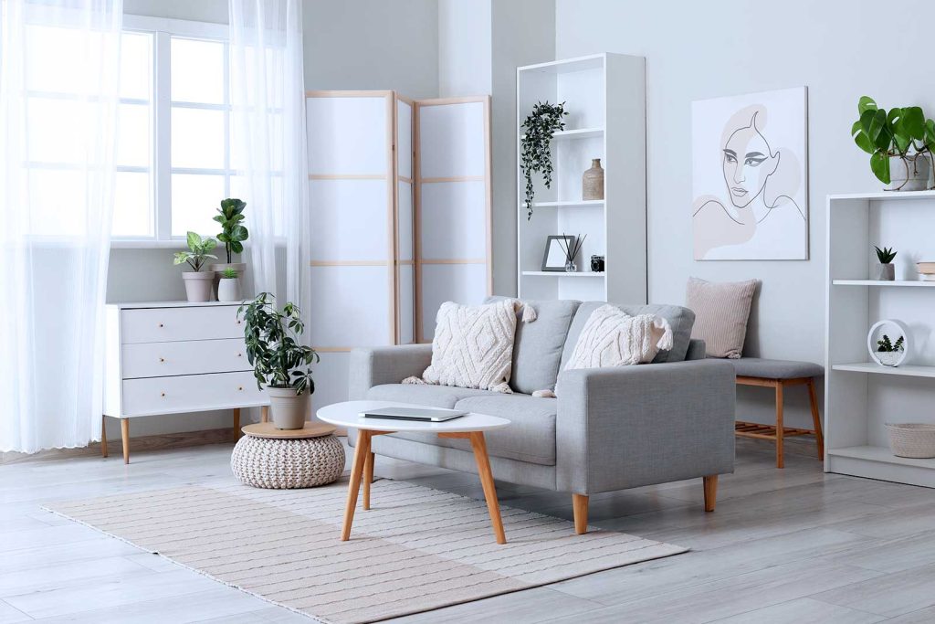 Sala moderna e minimalista com plantas e móveis em tons neutros.