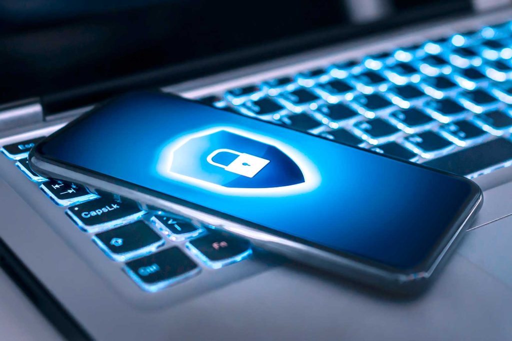 Celular com um cadeado de segurança na tela em cima de um teclado de notebook