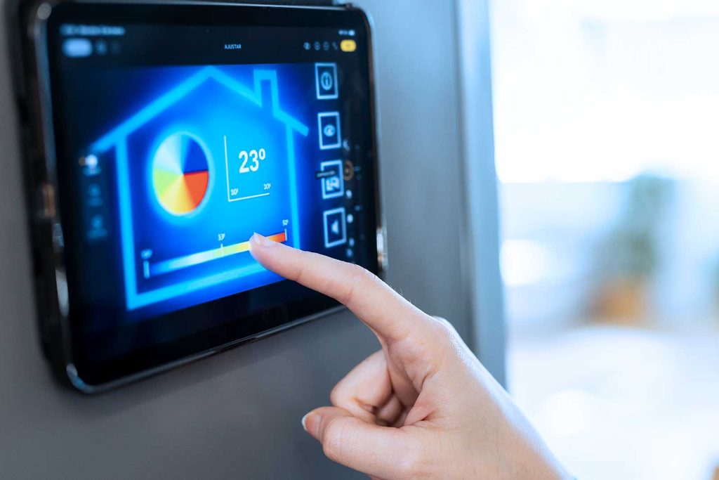 Pessoa controlando a temperatura de uma casa por meio de um tablet