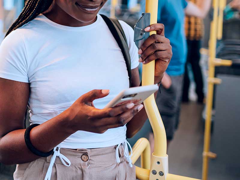 Pessoa usando smartphone em transporte público