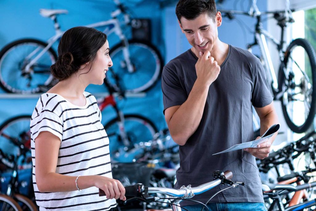 Atendimento em loja de bicicletas com cliente satisfeita.