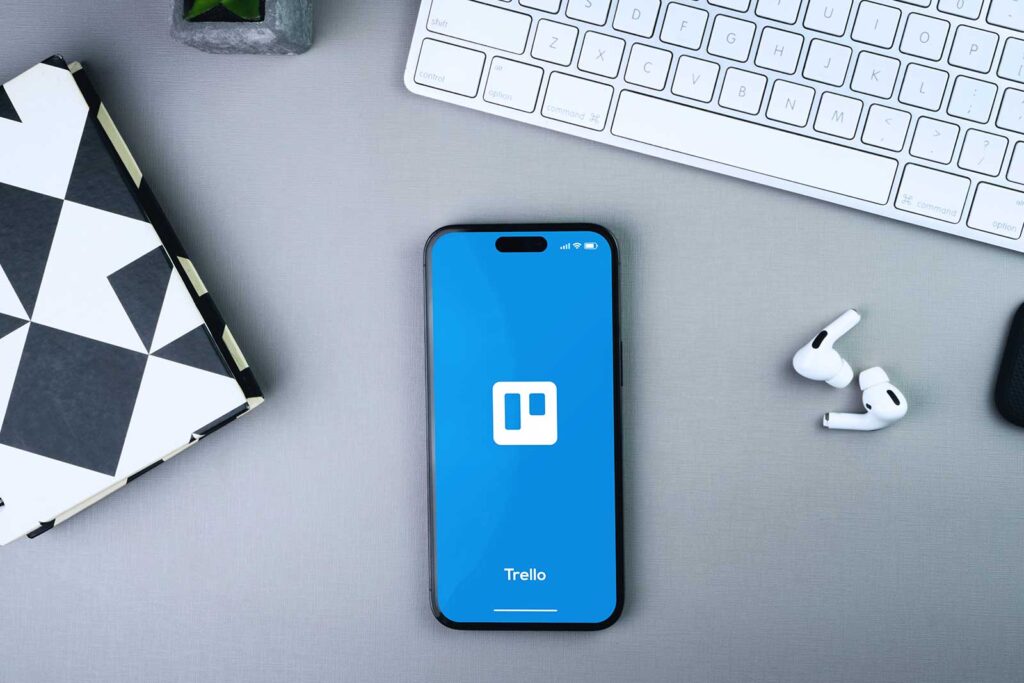 Tela inicial do Trello em smartphone sobre mesa