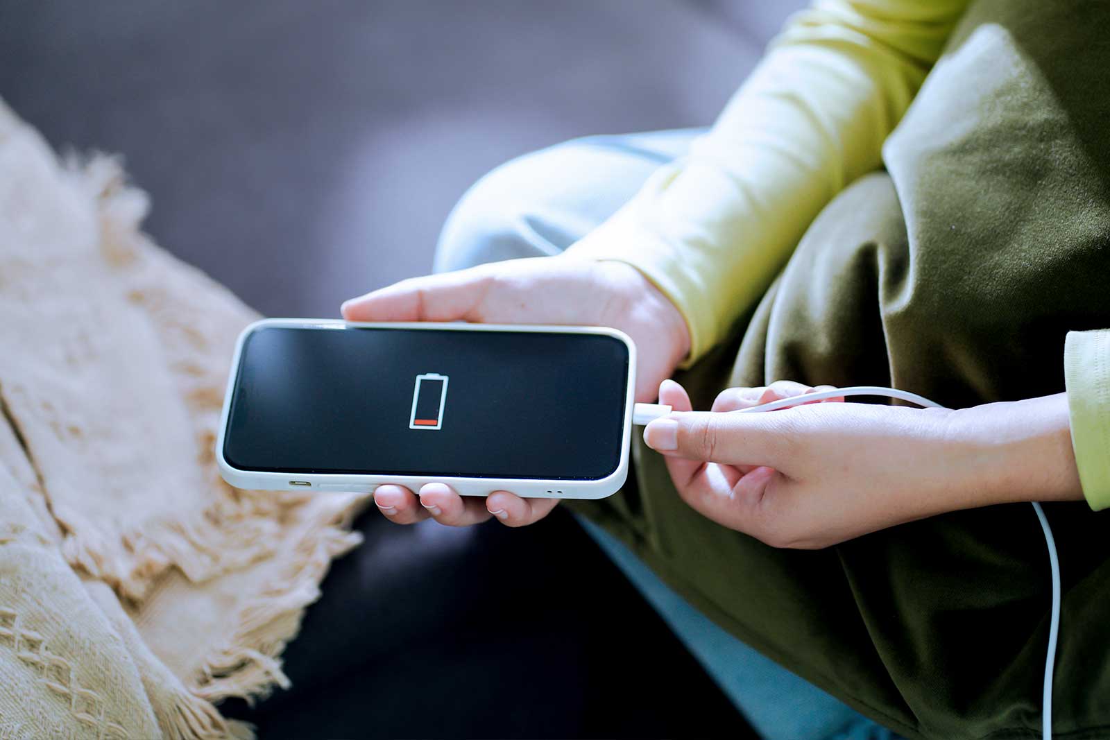 Carregador portátil conectado a smartphone em uso.
