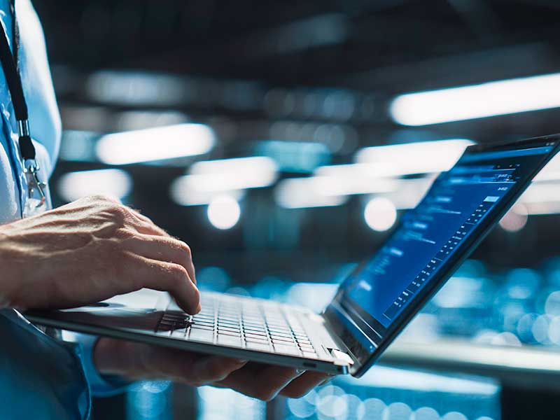 Homem digitando em laptop em ambiente de trabalho