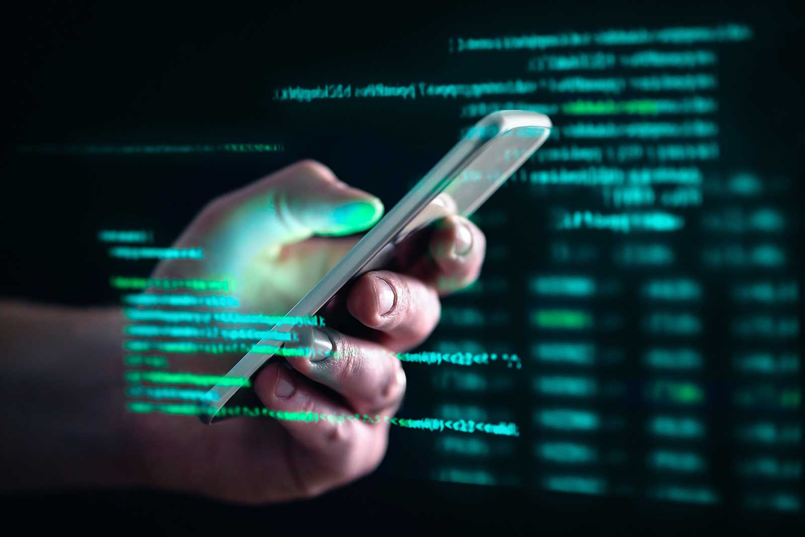 Pessoa segurando smartphone com códigos digitais
