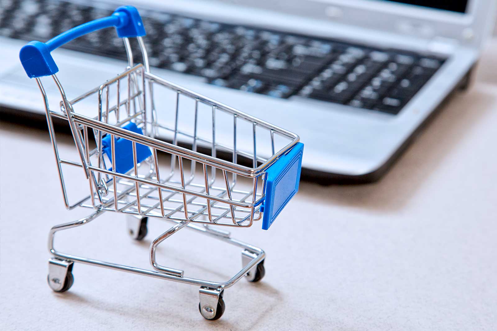 Carrinho de compras ao lado de um laptop