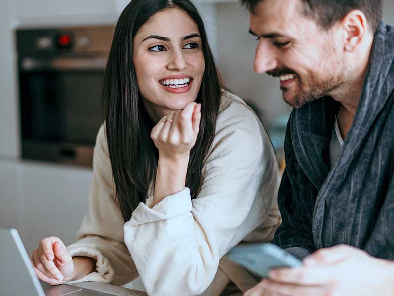 Casal sorridente conversando em casa
