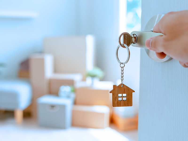 Chave com chaveiro de casa na porta de entrada