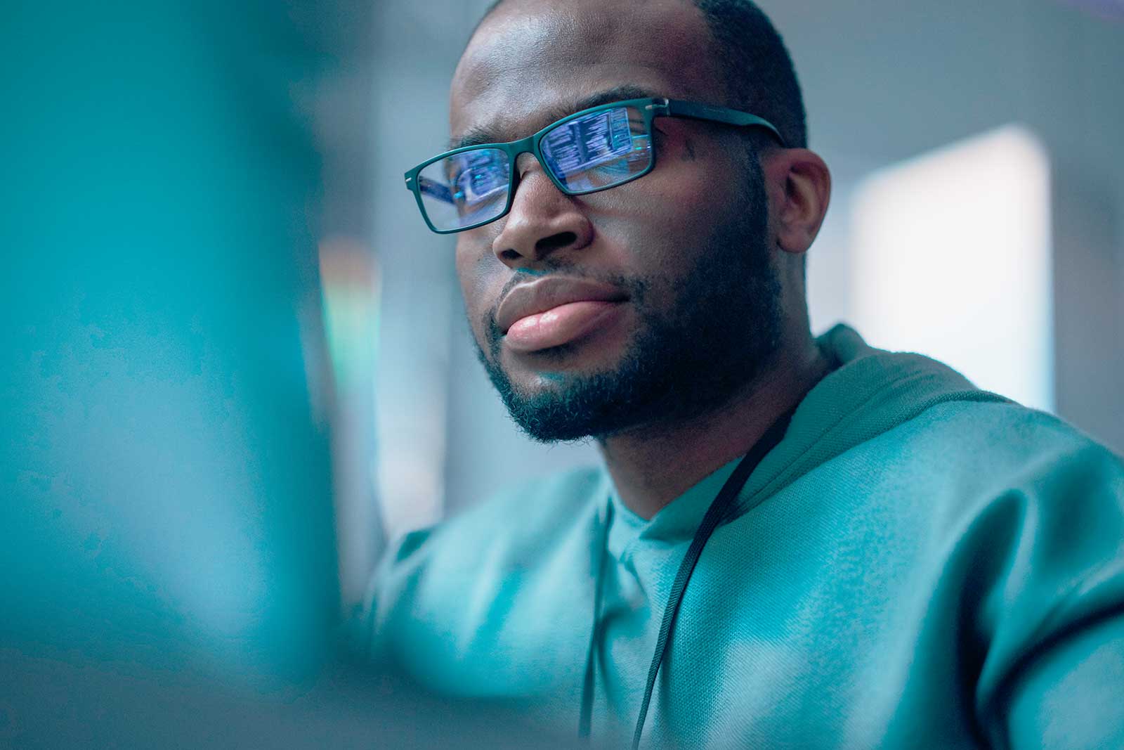 Homem com óculos focado em computador