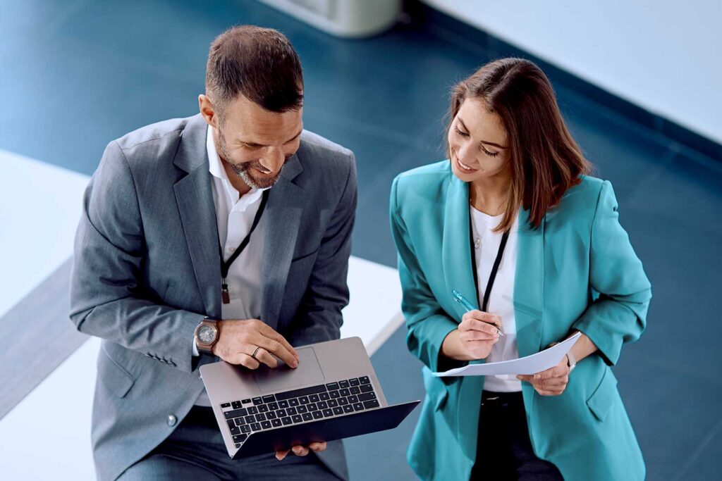 Profissionais analisando dados em laptop