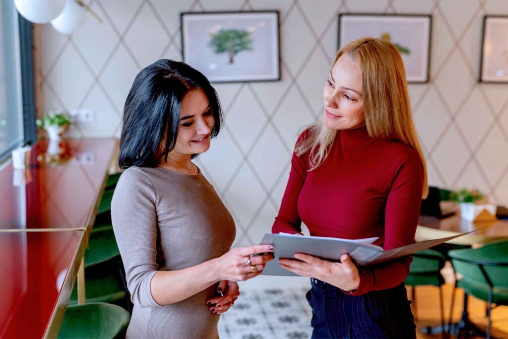 Duas mulheres conversando em café moderno