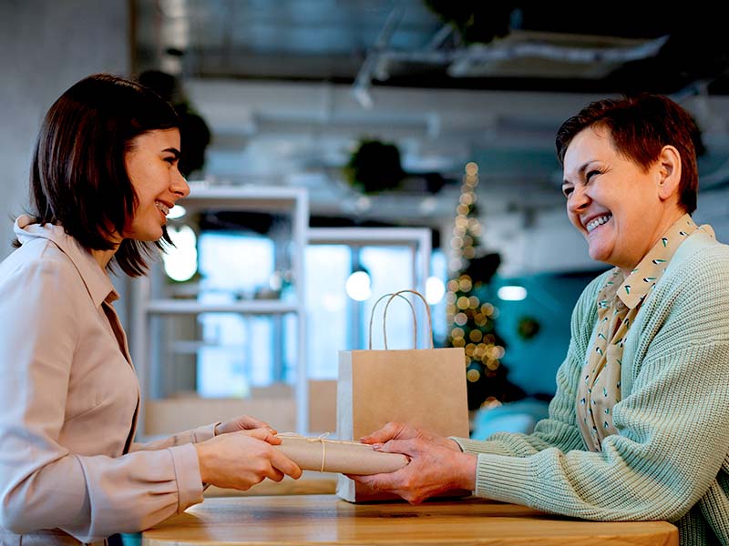 Dupla de mulheres trocando presente em ambiente descontraído