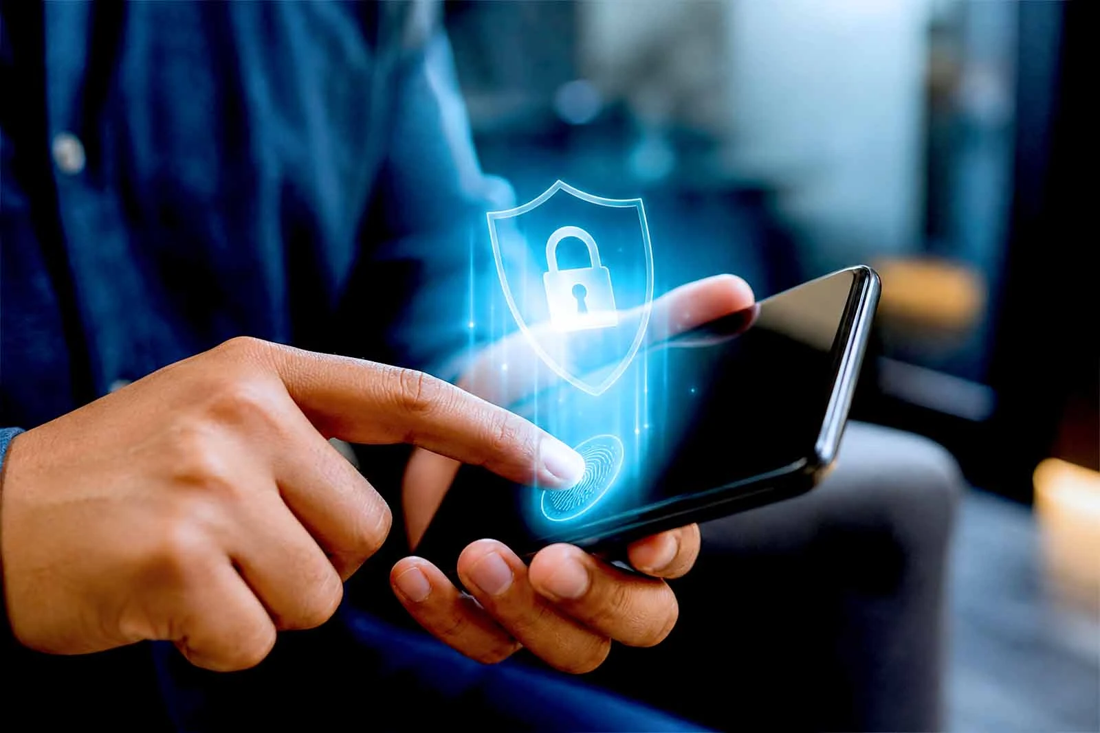 Mão tocando leitor digital de celular com holograma de escudo e cadeado aceso.