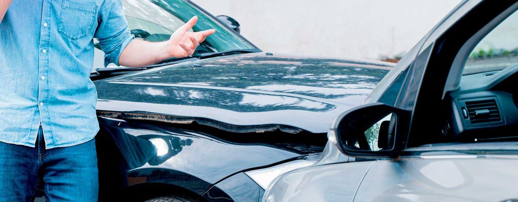 acidente-de-carro-homem-celular Homem usando celular após batida de carros.