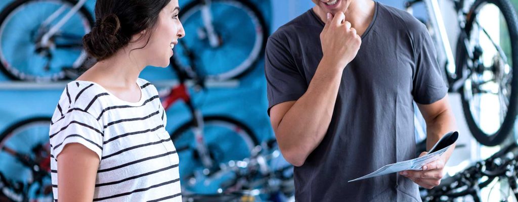 Atendimento em loja de bicicletas com cliente satisfeita.
