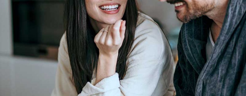Casal sorridente conversando em casa