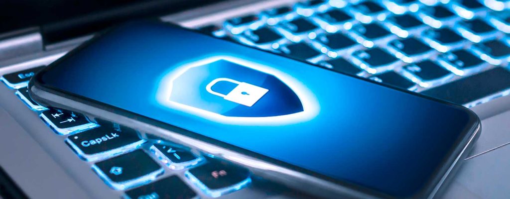 Celular com um cadeado de segurança na tela em cima de um teclado de notebook