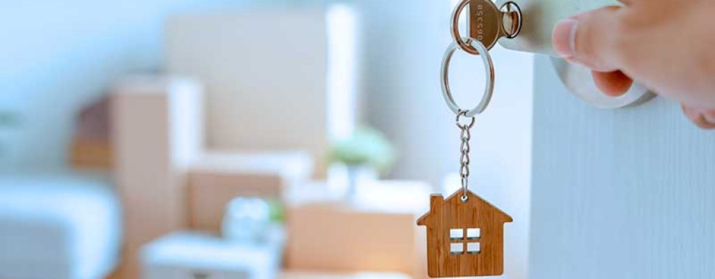 Chave com chaveiro de casa na porta de entrada