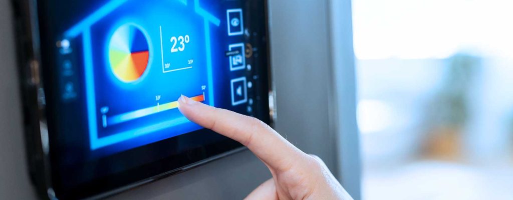 Pessoa controlando a temperatura de uma casa por meio de um tablet