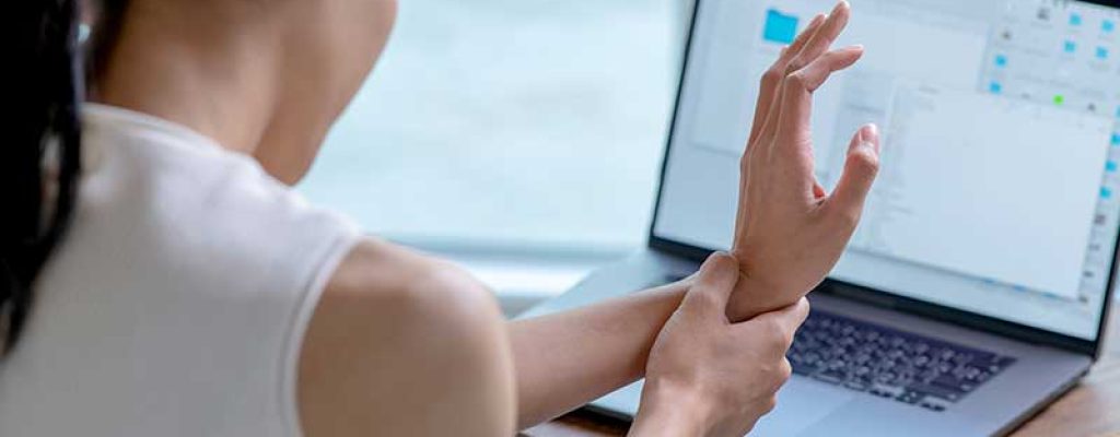 dor-no-pulso-laptop Mulher com dor no pulso em frente ao laptop