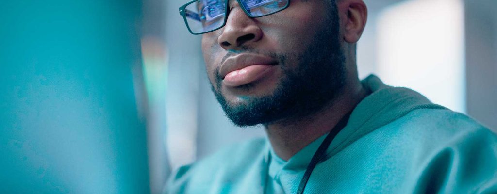 Homem com óculos focado em computador