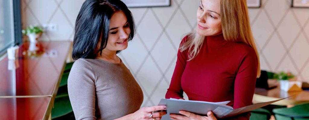 Duas mulheres conversando em café moderno