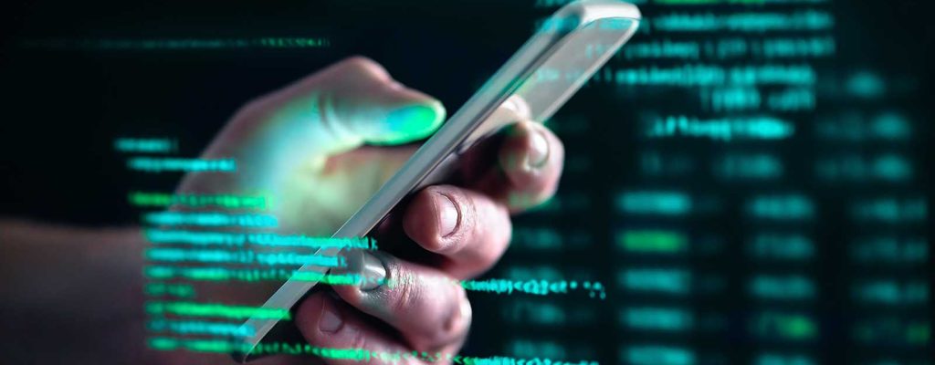 Pessoa segurando smartphone com códigos digitais