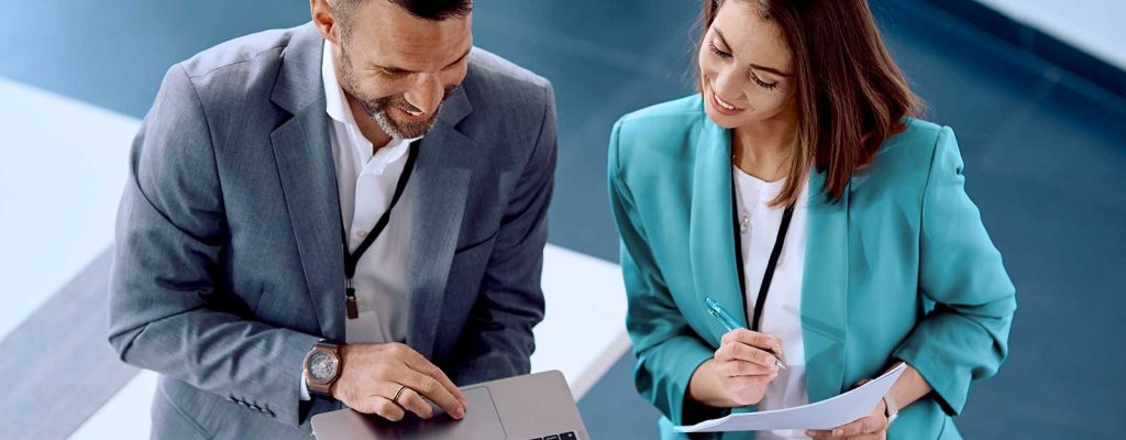 Profissionais analisando dados em laptop