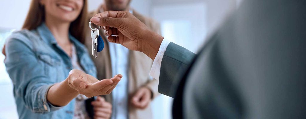 Pessoa recebendo chaves de uma nova casa